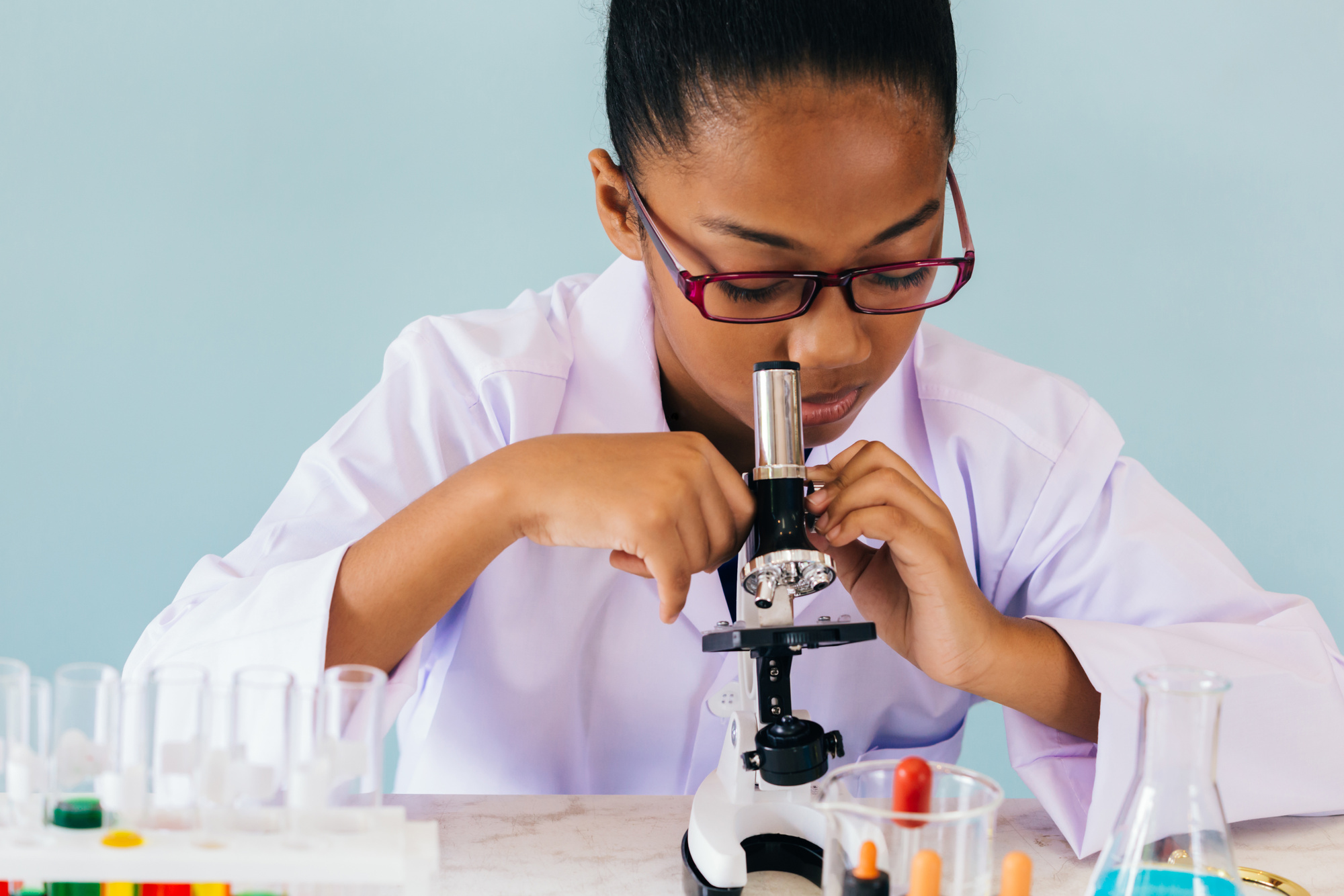 Young African American Kid Using Microscope in Lab