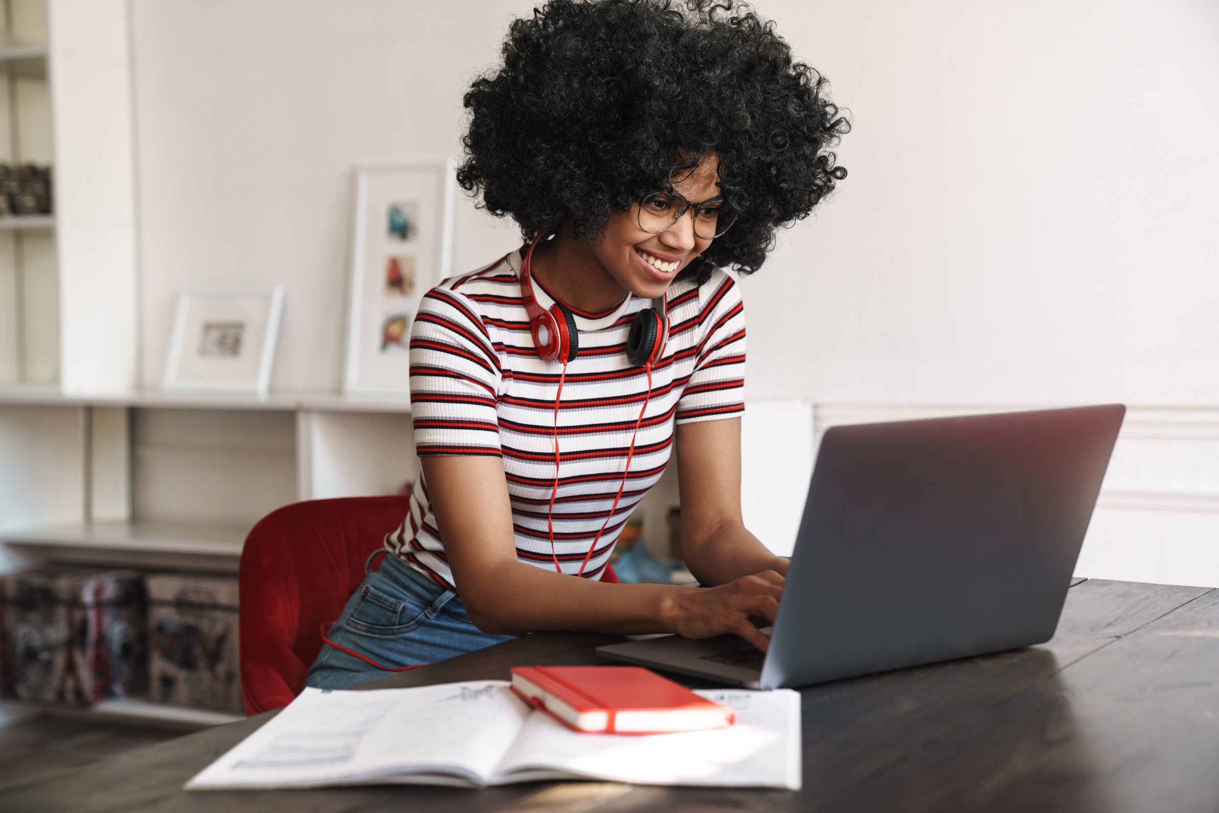 Smiling African American Student Girl Doing Homework with Laptop