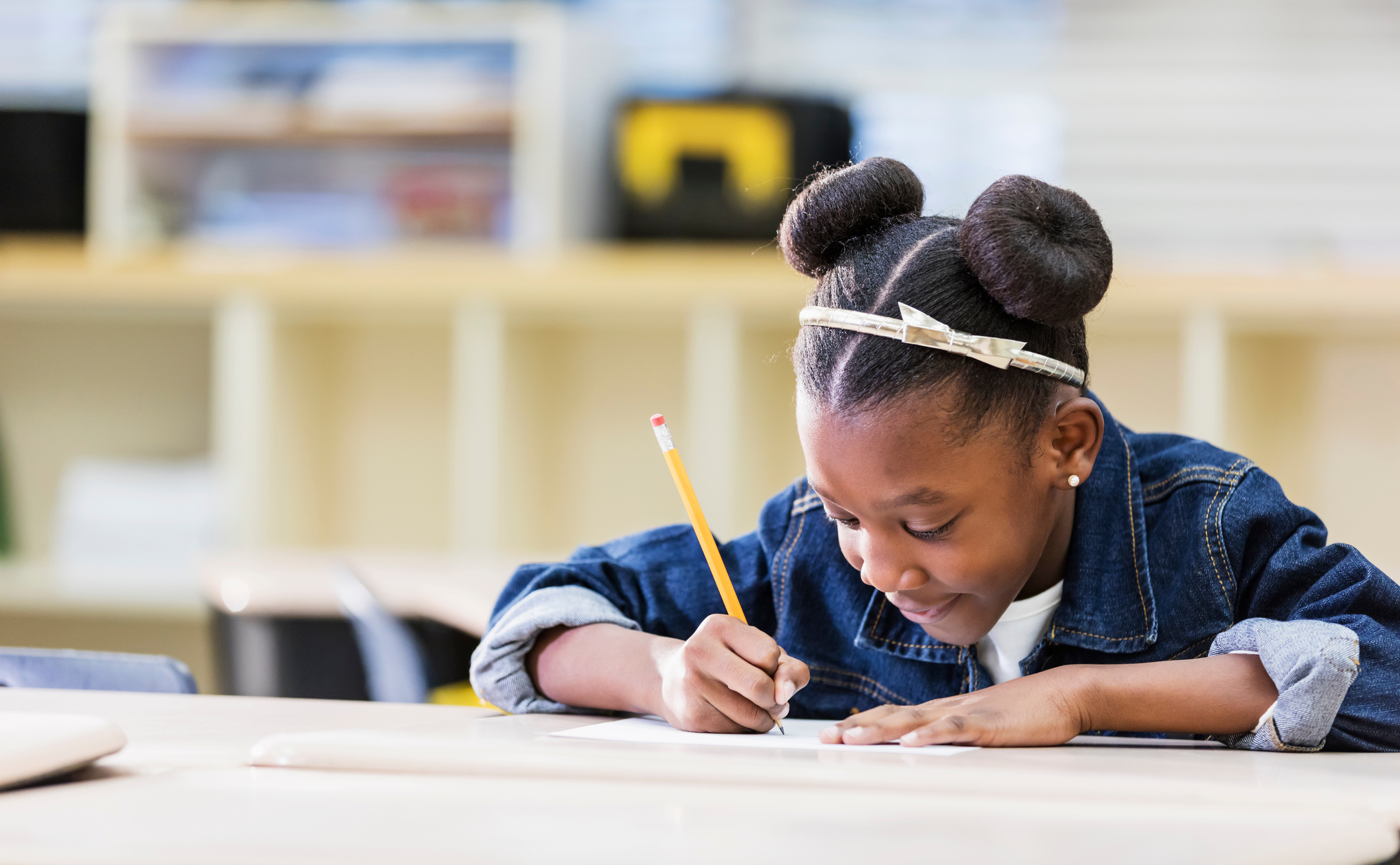 African-American elementary student writing in class